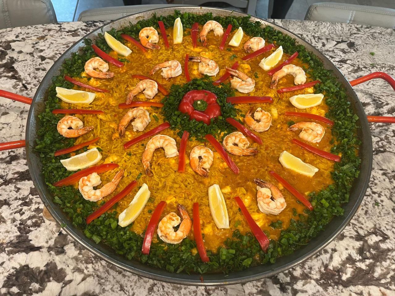 Shrimp Paella beautifully garnished with shrimp, peppers and lemons